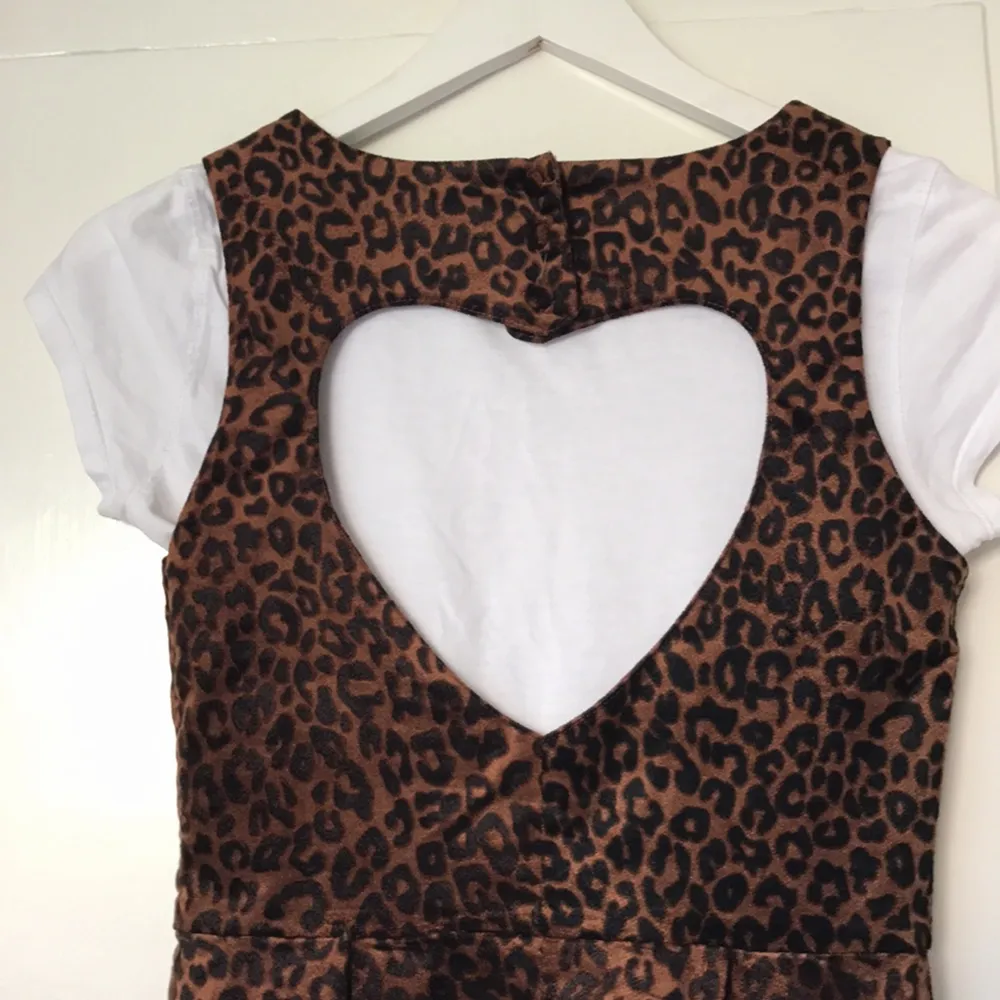 Leopardmönstrad kort klänning, hjärtformad öppning i ryggen. Lent, sammetsliknande material. Superfin både med och utan T-shirt under, eller med skärp i midjan (medföljer ej). . Klänningar.