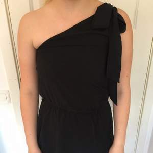 Fin svart klänning med en bar axel.
