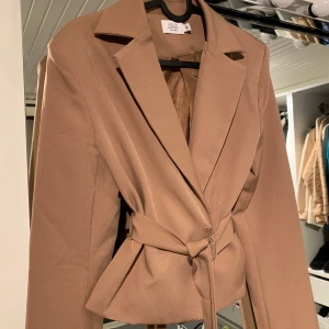 Skitsnygg kavaj - Croppad kavaj. Skitsnygg och inte använd. Storlek 34. Ena knappen sitter lite löst men det går att sy fast om man stör sig på det. 