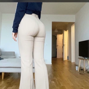 Beiga kostymbyxor - Jättefina beiga kostymbyxor från NA-KD som går ut som bootcut vid fötterna och har slits 💞