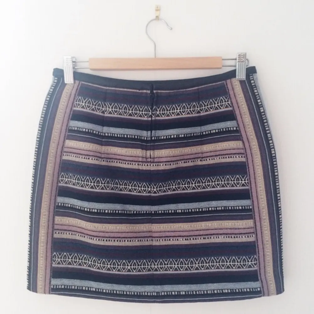 Mönstrad kjol från H&M med kantband i läder. Dragkedja baktill. Något kortare fram. Aldrig använd då den är för liten för mig. . Kjolar.