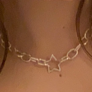Kedjehalsband med en stjärna i mitten - Ett kedjehalsband med en stjärna i mitten. Den är silvrig men skulle nästan säga att den är lite mer åt det vita hållet. 50 kr sammanlagt, frakten ingår i det priset. Funkar som om det var köpt från butik, inga svårigheter.