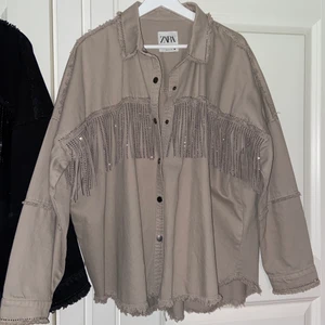 Zara jacka - Skitsnygg beige jacka från Zara, mycket populär och varit slutsåld! Köpte den i L för en oversize känsla vilket jag anser passar denna modeller mycket snyggare än en vanlig storlek. Tveka inte att skriva vid frågor eller bilder😀 nypris 500;- endast använd fåtal gånger. (Skulle säga att storlekar från 36-40 kan ha jackan beroende på hur man vill att plagget ska sitta)