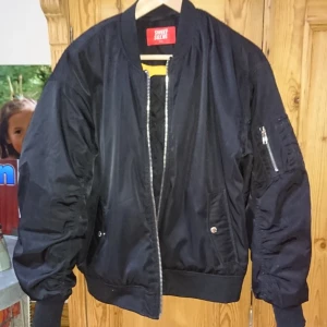  - En varm bomberjacka som är i bra skick men är använd så det blivit lite mörkt vid insidan av jackan (se bild) men inget man ser vid användning! 