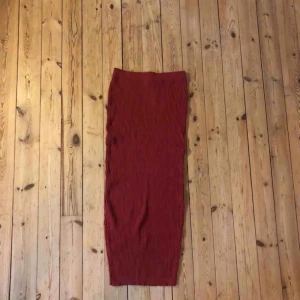  - Stickad långkjol i roströd färg. Mycket fint skick. Sprund bak. 