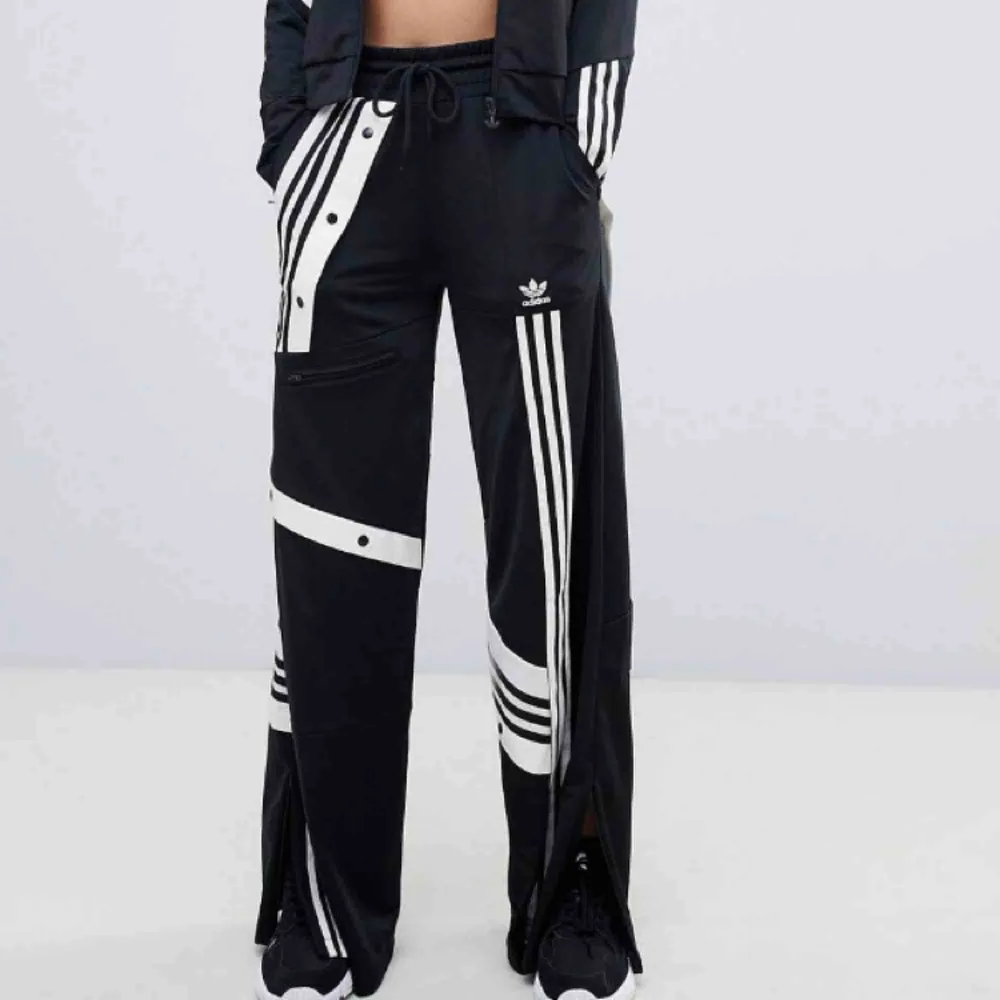 Trackpants från Adidas x Danielle Cathari! Vida och ganska långa (når till marken på mig som är 175) Endast använda 2-3 gånger! Nypris 900 kr!. Jeans & Byxor.