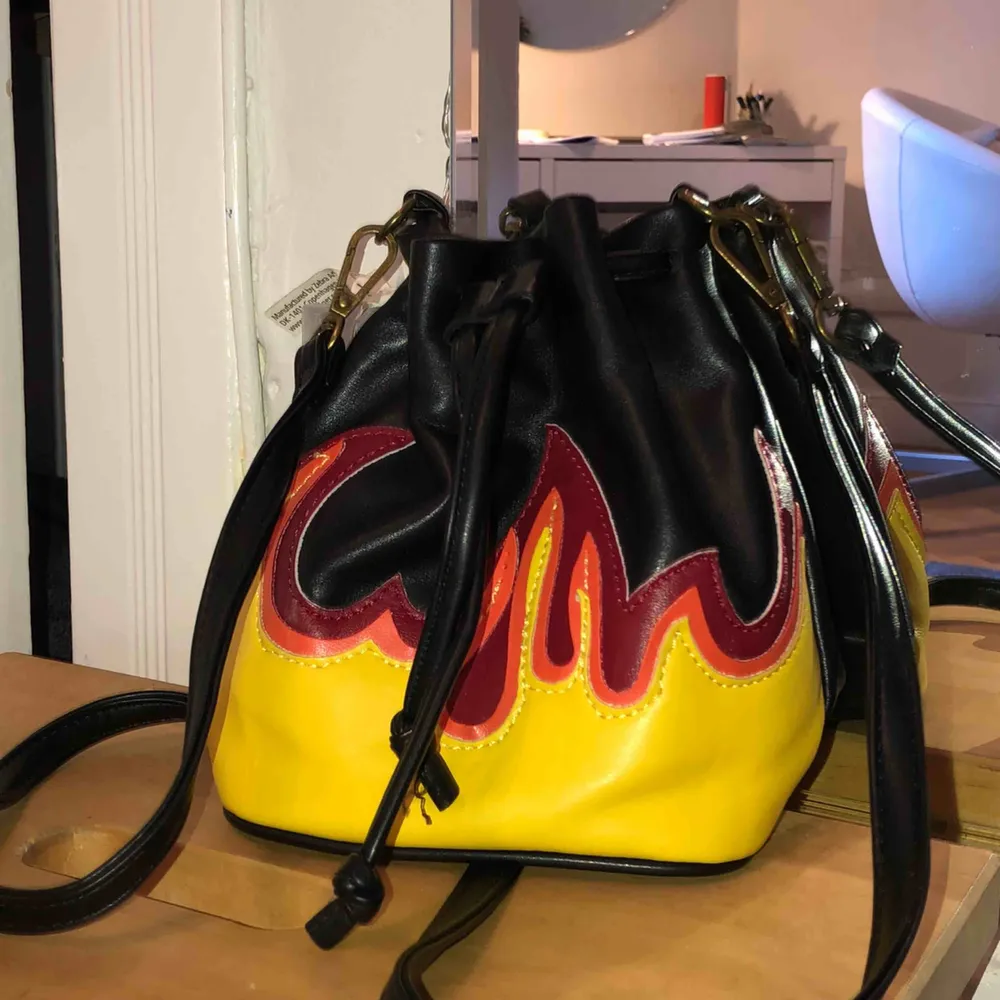 Liten väska från Bikbok med flammor på. Det är en fake-läderväska och den är i väldigt bra skick.. Väskor.