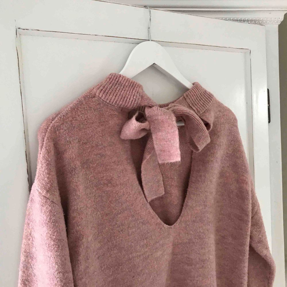 En rosa stickad tröja från Gina tricot, öppen i ryggen och en rosett i nacken. Använd ca 5 ggr. . Stickat.