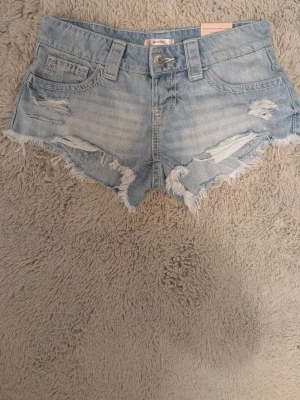 Lågmidjade jeansshorts  - Ett par lågmidjade jeansshorts från Gina Tricot, köpta förra året aldrig använda lappen sitter kvar