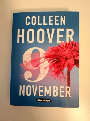 9 November av Colleen Hoover - En gripande roman av Colleen Hoover med blått omslag och en stor röd blomma. Boken handlar om kärlek, drömmar och ödet, och är utgiven av Lovereads. Perfekt för dig som gillar romantik och starka känslor. Har lästs en gång