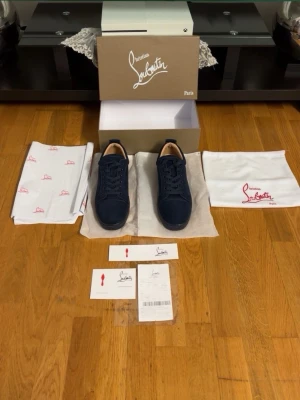Mörkblå sneakers från Christian Louboutin - Snygga mörkblå sneakers från Christian Louboutin med klassisk låg siluett. Skorna har ovandel i mocka, matchande mörkblå snören och diskret branding. Innersulan är ljus och skon har en stilren design som passar till det mesta. PRIS KAN DISKUTERAS!!!