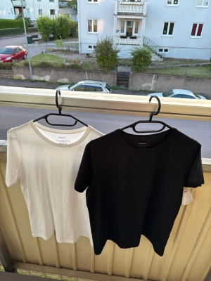 Svart och vit basic t-shirt - Två stilrena basic t-shirts i svart och vitt. Båda har rund halsringning och korta ärmar. Perfekta att matcha med jeans eller shorts. Tillverkade i mjuk bomull för skön känsla hela dagen. Dem är från newbody och väldigt sköna, de är nästan aldrig använda och säljs pga fel köp av storlek. Kan köpa en om man ej vill ha båda. Kom gärna med frågor.