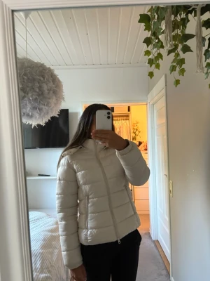 Vit puffjacka - Snygg vit puffjacka i storlek M. Jackan har dragkedja framtill och är lätt vadderad, perfekt för höst och vinter. Använd men i fint skick, inga synliga fläckar eller skador.