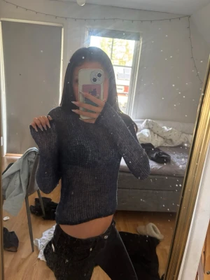Mörkblå ribbstickad croptröja - Säljer en mörkblå ribbstickad croptröja med långa ärmar och rund hals. Tröjan är tunnstickad och har en kroppsnära passform som ger en trendig look. Perfekt att styla med lågmidjade byxor 