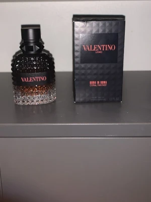 Valentino Uomo Born In Roma parfym - Valentino Uomo Born In Roma Coral Fantasy parfym i en elegant glasflaska med nitar och svart lock. Flaskan har en snygg färgskiftning från klar till mörkare ton och kommer med originalkartong. Volymen är 50 ml.