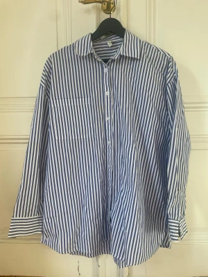 Blåvit randig oversized skjorta - Säljer en oversized skjorta med blå och vita vertikala ränder 