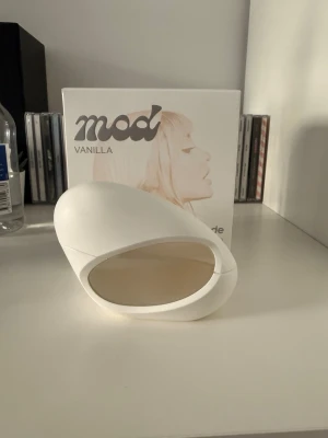 Mod Vanilla parfym - Unik parfymflaska i vit och transparent design med mjuka, moderna former. Doften heter Mod Vanilla och flaskan har en futuristisk look som sticker ut på hyllan. Perfekt för dig som gillar stilrena och trendiga detaljer i badrumsskåpet.