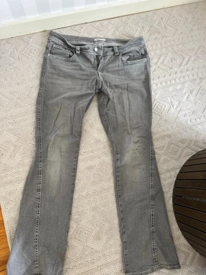 Grå bootcut jeans med vita sömmar - Säljer ett par grå bootcut jeans från Gina i modellen: y2k low twisted bootcut jeans. Köptes förra året för 499kr, är väldigt sparsamt använda och är i mycket gott skick! Tvättar självklart innan jag skickar, storlek 44🤍