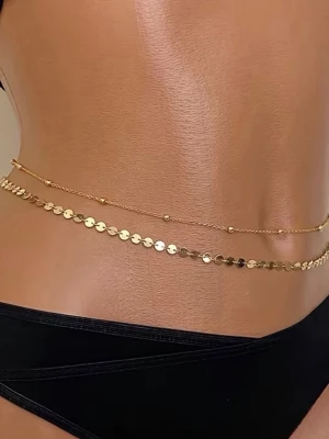 Dubbel midjekedja i guldfärgad  - Snygg dubbel midjekedja i guldfärgad metall med en tunn kedja och en kedja med små runda plattor. Perfekt accessoar för att lyfta din outfit och ge en trendig touch. Passar till både strand och festival.