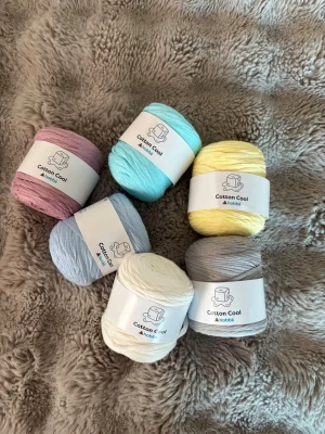 T-shirt garn - Säljer 6 helt nya nystan Hobbii Cotton Cool i fina pastell- och neutrala färger (se bild).  Cotton Cool är ett mjukt och lätt bandgarn i 100 % bomull. Den platta, ihåliga strukturen ger en vacker maskbild samtidigt som projekten blir lätta och bekväma. Perfekt till både stickning och virkning!  Vikt: 100g/styck  🧵 Rekommenderade verktyg:  * Stickor: 5 mm * Virknål: 6 mm  ✔️ 100 % bomull ✔️ Maskintvättbart ✔️ Oanvänt  