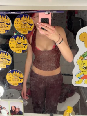 Vinröd mesh halterneck topp - Säljer en vinröd mesh halterneck topp med öppen rygg och croppad passform. Toppen är ärmlös och har en lätt transparent look som ger en edgy vibe. Perfekt för dig som vill sticka ut och köra en trendig stil.