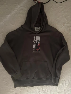 Pull and bear itachi hoodie - Säljer grå itachi hoodie köpt från pull&bear. Har använts vid flera tillfällen men är inte sönder nånstans. Observera att tråden/snöret i luvan saknas men huvan har fin passform utan det också. Dens storlek är xl men dens passform är liten i storlek. 