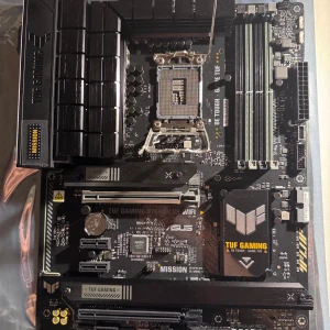 Asus Tuf Gaming B760-Plus WIFI - ddr5-Komplett - Säljer ett ASUS TUF GAMING B760-PLUS WIFI moderkort för Intel LGA1700. Specifikationer: * ASUS TUF GAMING B760-PLUS WIFI * Intel B760-chipset * LGA1700 * DDR5 * WiFi + Bluetooth * PCle 5.0 * M.2 NVMe-stöd * ATX Skick: Sockeln ser fin ut och moderkortet ar val omhandertaget. Den är testad innan den packades. Komplett med originalförpackning och alla tillbehör på bilden följer med. Inte kommit till anvandning då jag kör AMD, endast använt då jag testa så det fungerade. Kan skickas väl packat.