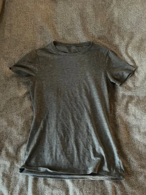 Grå t-shirt från Intimissimi - En enkel och stilren grå t-shirt från Intimissimi i mjuk Supima-bomull. T-shirten har rund halsringning och korta ärmar, perfekt för en clean och avslappnad look. 