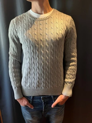  kabelstickad Ralph Lauren  - Crewneck från Ralph Lauren!                              Storlek: M.                                                                  Färg: Grå                                                           Skick: 9/10                                                         Nypris: 2000kr                                                           Hör av er vid frågor o funderingar!