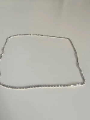 Klassiskt silverfärgat halsband - Säljer ett stilrent halsband i silverfärg med tvinnad kedja. Halsbandet har en enkel karbinhake och passar perfekt för dig som gillar minimalistiska accessoarer. Materialet ser ut att vara metall med blank finish. Perfekt att bära som det är eller att kombinera med andra smycken.