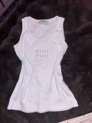 Vitt ribbat linne  - Superfint vitt ribbat linne med diamantstenar ”miumiu” är osäker om den är äkta för köpt av en annan säljare på plick. Pris kan diskuteras vid snabb affär:)