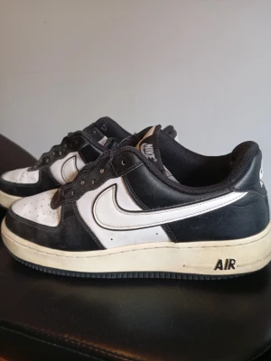 Nike Air Force 1 svartvita sneakers - Klassiska Nike Air Force 1 sneakers i svart och vitt med vit sula och svart yttersula. Skorna har den ikoniska swoosh-loggan på sidan och AIR-text på hälen. Ovandelen är i läder och designen är lågskuren för en clean och tidlös look. Dom är mycket använda. Dom är äkta. Har tyvärr inte box. Pris kan såklart diskuteras🙌. Mvh Rasmus.