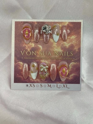 Elara (XS);Medium Almond - Handgjorda press-on nails i rosa, nude med glitter, gulddetaljer, kristaller och dekorativa 3D-charms. Ett elegant och glittrande set med lyxiga detaljer.