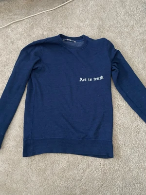 Blå sweatshirt Zadig & Voltaire - Mörkblå sweatshirt från Zadig & Voltaire med trycket 'Art is truth' på bröstet. Tröjan har rund halsringning, långa ärmar och ribbade muddar. Perfekt för en avslappnad och stilren look.XS MEN SITTER MER SOM S