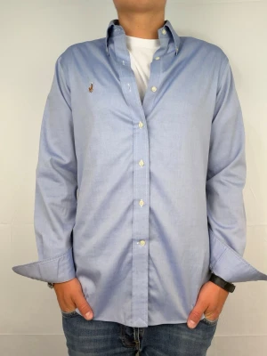 Ralph lauren skjorta ljusblå M - Säljer denna otroligt snygga ralph lauren skjorta. Riktigt skönt material . Size 15 1/2 som motsvarar M. Modellen är 180cm. Bredd 46cm,  längd 68cm! Fint skick, nytvättad och ny strykt så att skillnaden på denna och en ny ska vara minimal! Fraktar samma dag som köp, kan gå ner i pris vid snabb affär! 🤩