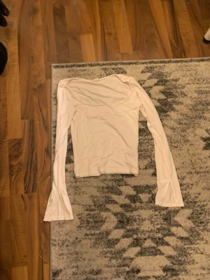 Vit långärmad topp från Gina Tricot - Säljer en enkel och stilren vit långärmad topp från Gina Tricot, elevated basics-kollektionen. Toppen har en rak passform och är tillverkad i mjukt material som passar perfekt till alla outfits.
