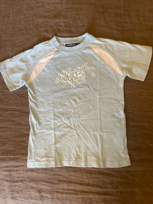 Ljusblå barn t-shirt från Dubster stl.116 - En ljusblå  barn T-shirt stl.116 , bomull, i bra skick, finns en läggning på ryggen 
