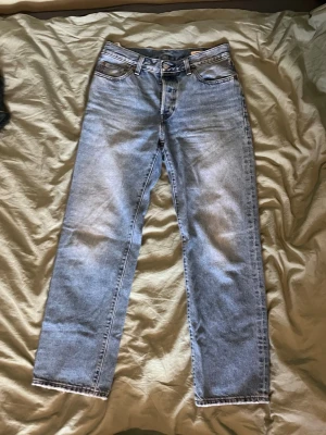 Vintage selvedge Levis 501 90’s - Säljer ett par ljusblå raka jeans med klassisk femficksmodell och selvedge-detalj vid benslutet. Jeansen är tillverkade i kraftig denim, perfekt för dig som gillar en tidlös och clean look. Selvedge, bra skick och storlek 27/30 men är rätt stora i midjan. Hör av dig vid minsta fundering!