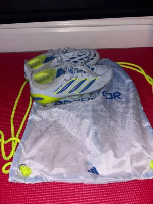 Adidas Predator elite ag fotbollsskor - Säljer ett par  Adidas Predator fotbollsskor som är till för spel på gräs.(AG) Medföljer en matchande dragskopåse. Perfekta för dig som vill sticka ut på planen! De är använda ca 10 ggr, aldrig matchspel. Det ända tecknat på användning är att de är lite  smutsiga. Nypris 3499kr 