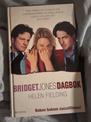 Bridget Jones dagbok av Helen Fielding - Rolig och charmig roman om Bridget Jones, skriven av Helen Fielding. Boken har ett färgstarkt omslag med bilder från filmatiseringen och är utgiven av Richters. Perfekt för dig som gillar humor, romantik och vardagsdrama.