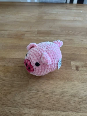 Virkad rosa gris - Söt liten handvirkad gris i mjukt, fluffigt garn. Grisen är ljusrosa med mörkare rosa tryne, svarta ögon och små öron. Perfekt som dekoration eller gosedjur. Unik och charmig detalj till rummet.