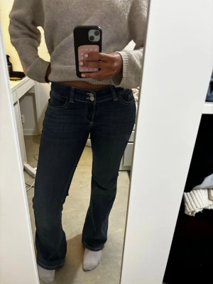 Mörkblå jeans Nelly  - Säljer ett par mörkblå bootcut jeans som endast använts två gånger. Jeansen har låg midja. De virala Nelly jeansen för ett lägre pris!!