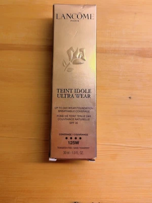 Lancôme Teint Idole Ultra Wear 125W  - Lancôme Teint Idole Ultra Wear foundation i nyansen 125W. Kommer i en elegant guldig förpackning med svart text och rosdetalj. Ger långvarig täckning och har en flytande formula. Innehåller 30 ml.