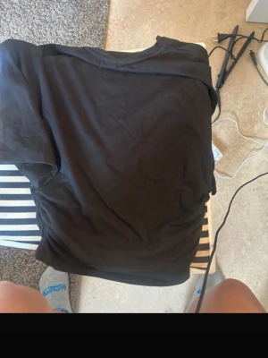 Svart basic t-shirt med rund hals - En enkel svart t-shirt med rund hals och korta ärmar. Perfekt att matcha med jeans eller shorts för en clean och stilren look. T-shirten har en klassisk passform och är gjord i mjukt bomullstyg.