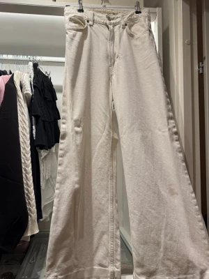 Vida vita jeans från Lee - Säljer ett par vita jeans från Lee med medelhög midja och riktigt vida ben. Klassisk femficksmodell med Lee-logga på bakfickan. Jeansen är gjorda i ett tjockare denimtyg och har dragkedjegylf. Perfekta för dig som gillar en avslappnad och trendig stil. Finns fläckar. Midjemåttet 34 cm 29cm från midja till skrev, innrebenslängd 68cm 