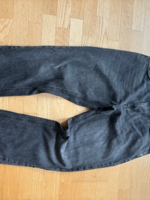 Svarta flerad Zara jeans  - Säljer ett par svarta loose fit jeans med raka ben och klassisk femficksmodell. Jeansen har en tvättad look och är tillverkade i denim. Perfekta för en avslappnad och trendig stil.