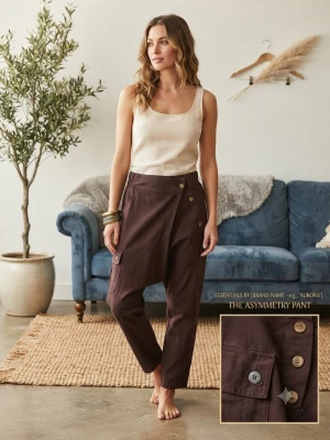 Bruna asymmetriska byxor med knappar - Unika bruna byxor med asymmetrisk design och dekorativa knappar framtill. Byxorna har en lös passform och croppad längd som ger en avslappnad och trendig look. Tillverkade i ett mjukt tyg som ser ut att vara bomull eller linneblandning.