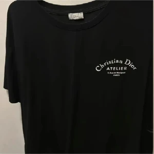 Svart t-shirt  - Snygg svart t-shirt från d!or tryck både fram och bak. Perfekt för en stilren look med en touch av lyx. Köpte på Vinted o han sa den var äkta men jag är inte säker där av priset men enligt mig så verkar den bra kvalité men har inget äktighets bevis . Är storlek M men stor i storleken mer L Xl