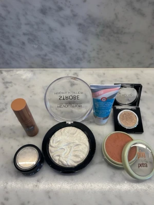 Blandade sminkprodukter - Säljer 6 stycken sminkprodukter som endast har använts någon enstaka gång. Två ögonskuggor, en highlighter, ett rouge, en primer och en liquid bronzer. Varierande märken, bl.a. benefit och Isadora 🩷