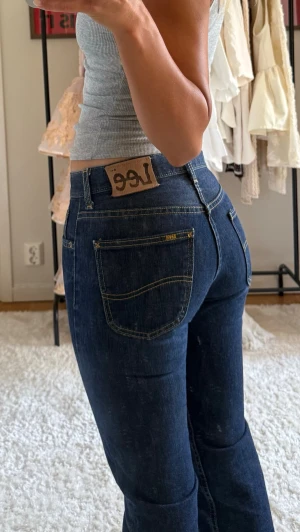 Mörkblå bootcut jeans från Lee - Säljer ett par klassiska mörkblå bootcut jeans från Lee. De är mid waist och storleken är W28 L32
